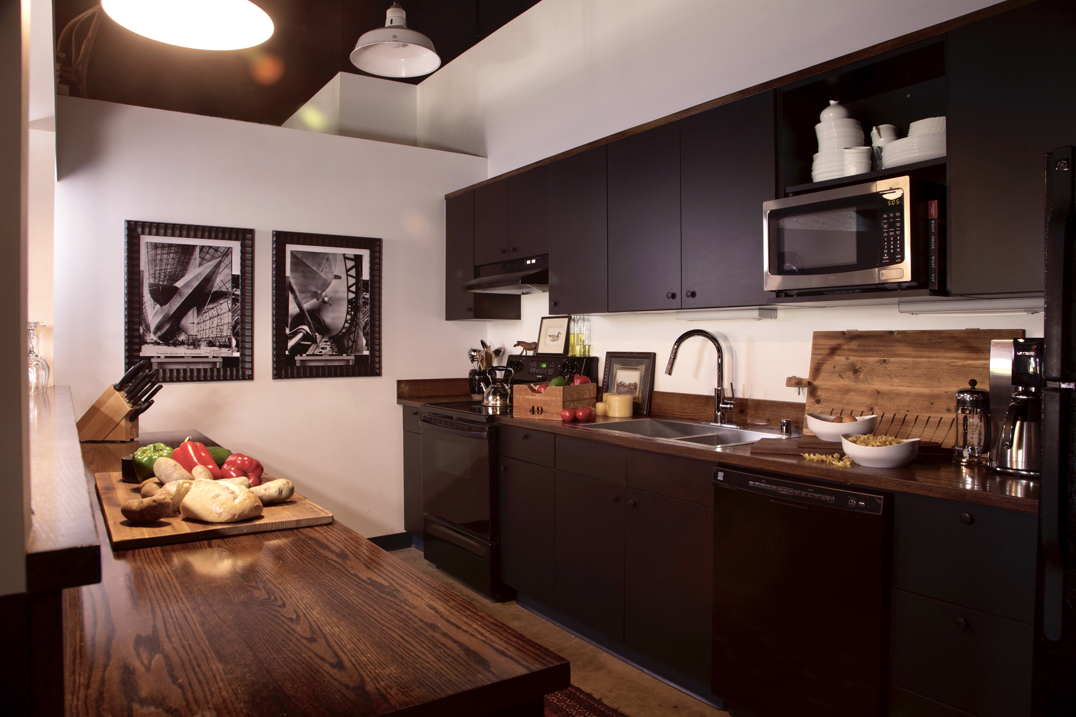 Giving contractor-grade prefab cabinets a smart coat of black, adding simple black appliances and accenting with oak countertops dress up this Montana loft kitchen while keeping it budget-friendly.