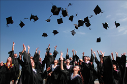 Graduates at graduation throwing caps into the air