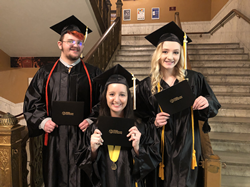 Three graduates pose together