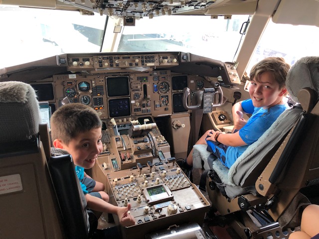 Brody, age 6, and older brother Jameson (right) sit in the flight deck of a Delta aircraft