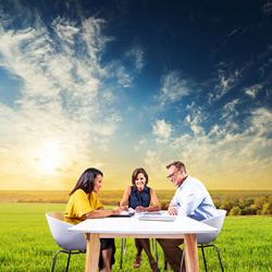 A team working at a table in natural sunlight, which NorbSMILE tube lights mimic.