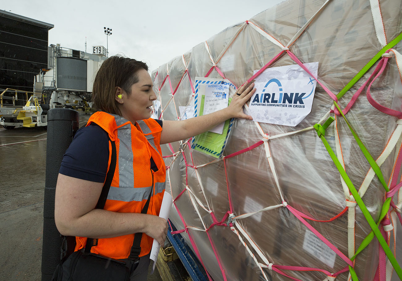 Airlink's senior humanitarian programs manager Stephanie Steege inspects aid cargo as it is loaded on to United's relief flight.