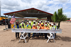 construction workers pose with beam.