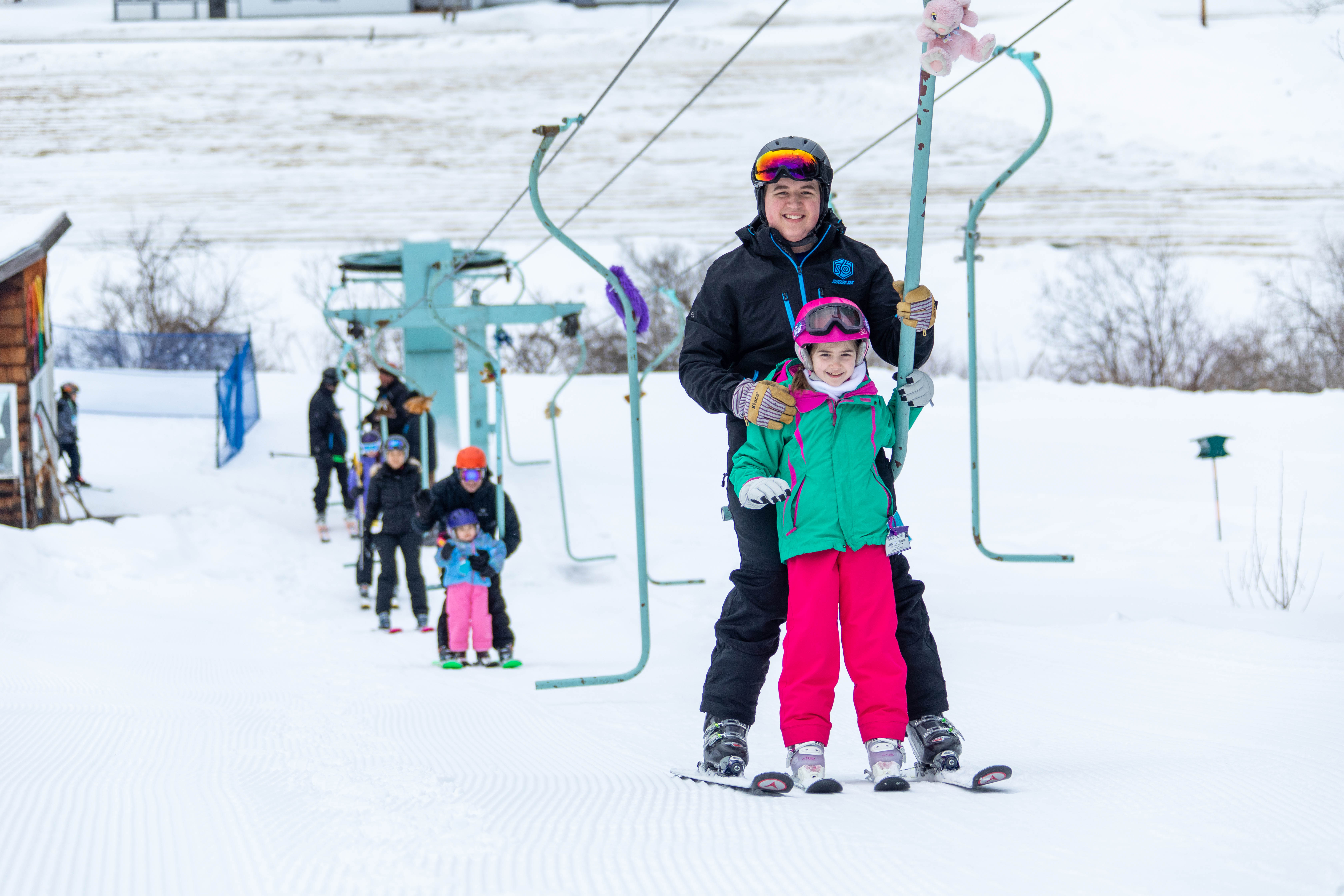 Instructor Aiden Shoemaker helps a student ride the J bar at Suicide Six Ski Area in Woodstock, Vt. Suicide Six's FUNdamentals program is the longest running snow sports school in the country.