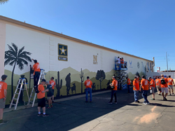 MaintenX team members paint a veterans’ mural alongside Team Depot.
