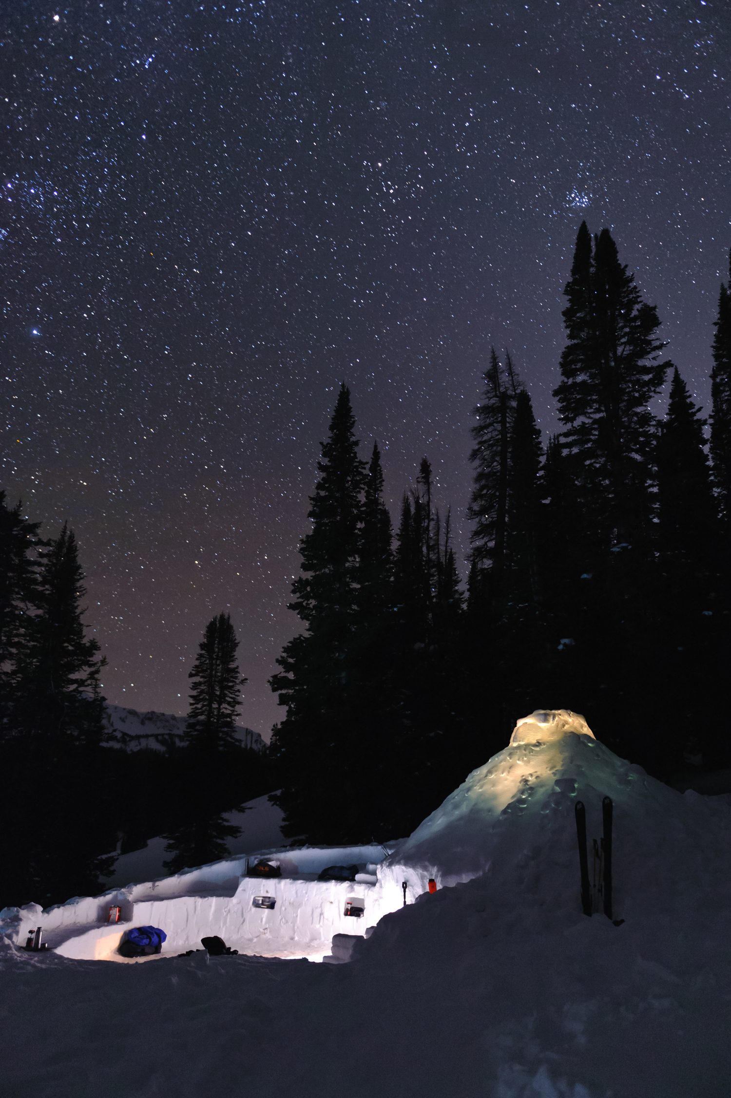 Real-world skills from NOLS Wyoming winter backcountry adventure include learning to build snow shelters and sleeping in them under the stars (photo by Fredrik Norrsell/NOLS).