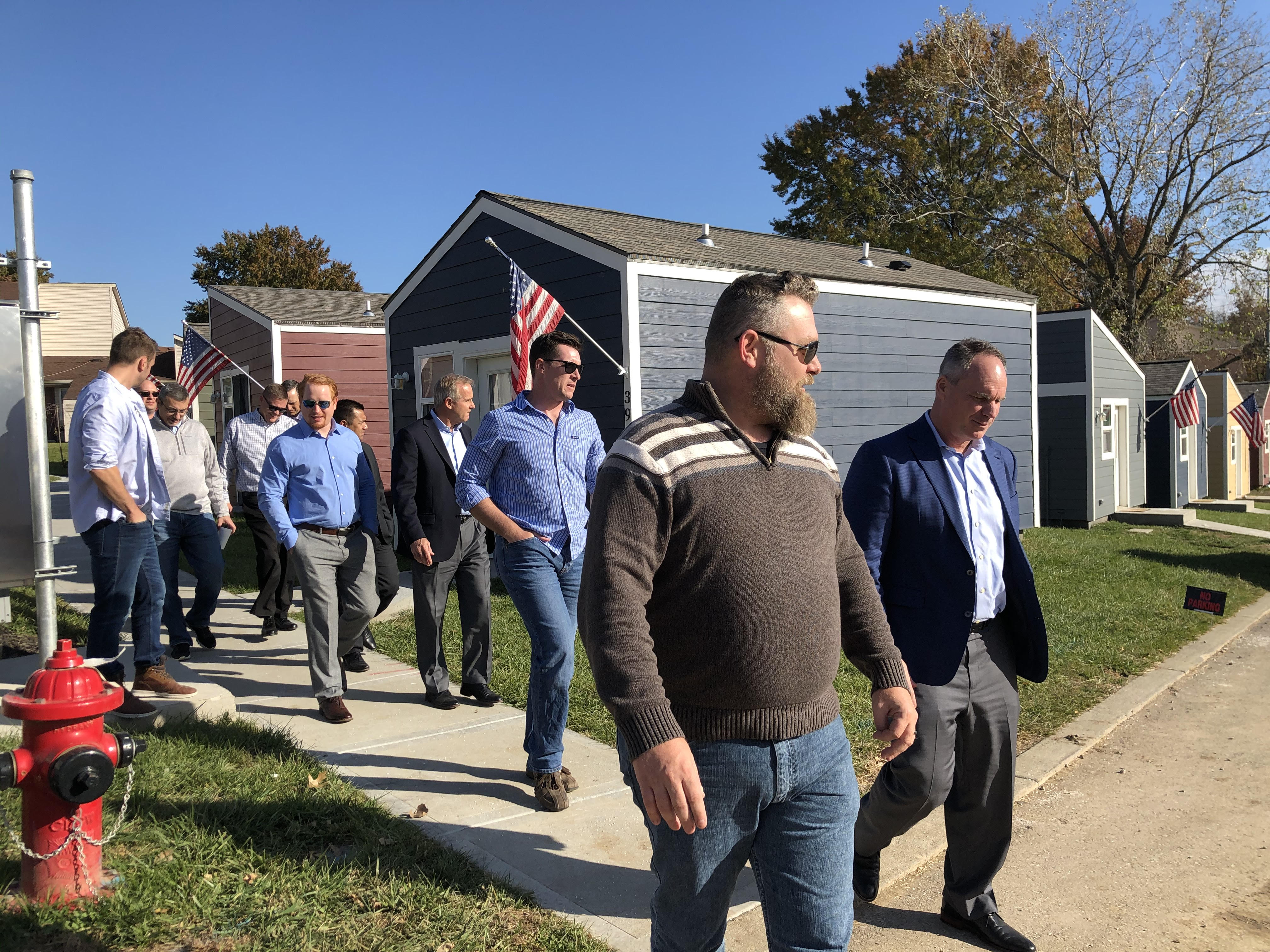 NASB CEO Paul Thomas tours VCP tiny village homes with employee veterans.