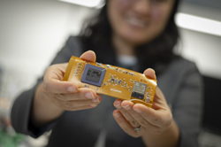 Professor Ulkuhan Guler shows off an early prototype of the miniaturized, wearable device that will one day monitor infants’ blood oxygen levels.