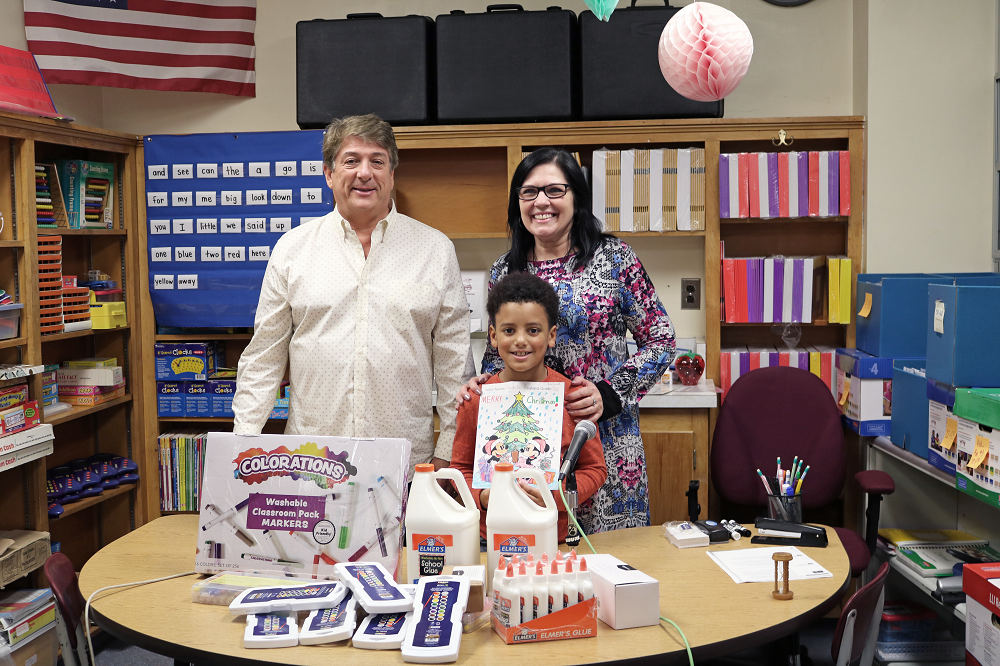 Sam Boak presenting art supplies to coloring contest winner and lead art teacher, Susan Farkas