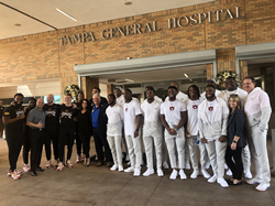 Outback Bowl players bring cheer to kids by visiting Tampa General Hospital's children's wing and passing out posters, pennants and shirts, and signing autographs.