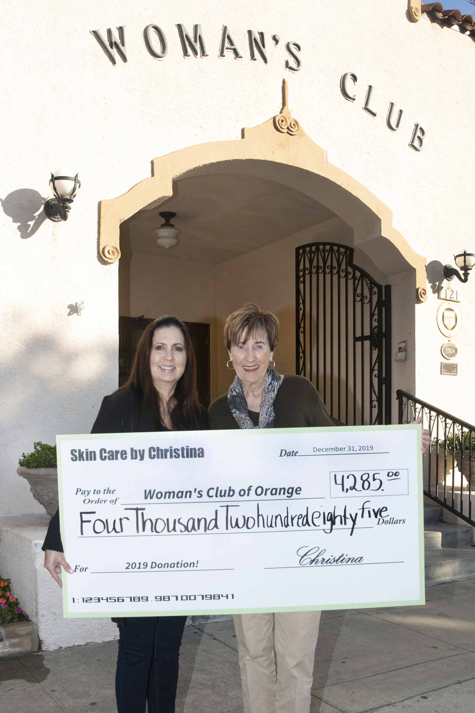 Skin Care by Christina owner Christina Martinez presents Woman's Club of Orange President Cheryl Krause with 2019 donation.