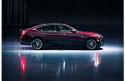 2020 Cadillac CT5 Premium Luxury exterior side shot with dark red maroon paint color lit in an empty showroom