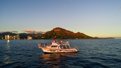 Guests boat past Waikiki on a sunset dinner cruise.