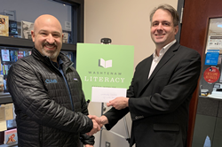 Climb Marketing President Jeremy Lopatin presents a donation to Nick Lacy, the Corporate & Individual Giving Manager for Washtenaw Literacy