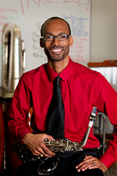 Mickey Smith Jr. in red shirt with saxophone