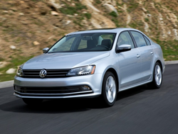 The front view of a 2017 Volkswagen Jetta 1.4T SE driving down a road.