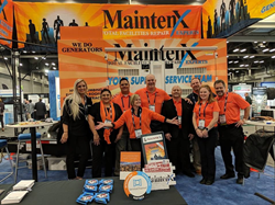 MaintenX providers stand together in front of their branded banner and generator at a restaurant facility convention.