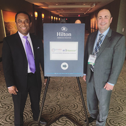 Two men standing next to sign at HR Conference