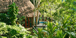 A thatched-roof suite surrounded by jungle at Chaa Creek,  Belize