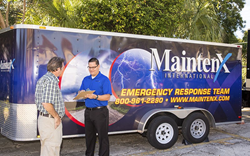 MaintenX team member stands in front of a maintenance truck helping a customer.