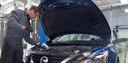 Image of a Nissan Service Technician servicing a Nissan vehicle's engine