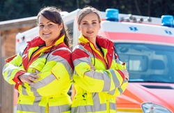 Two women paramedics standing in front of an ambulance