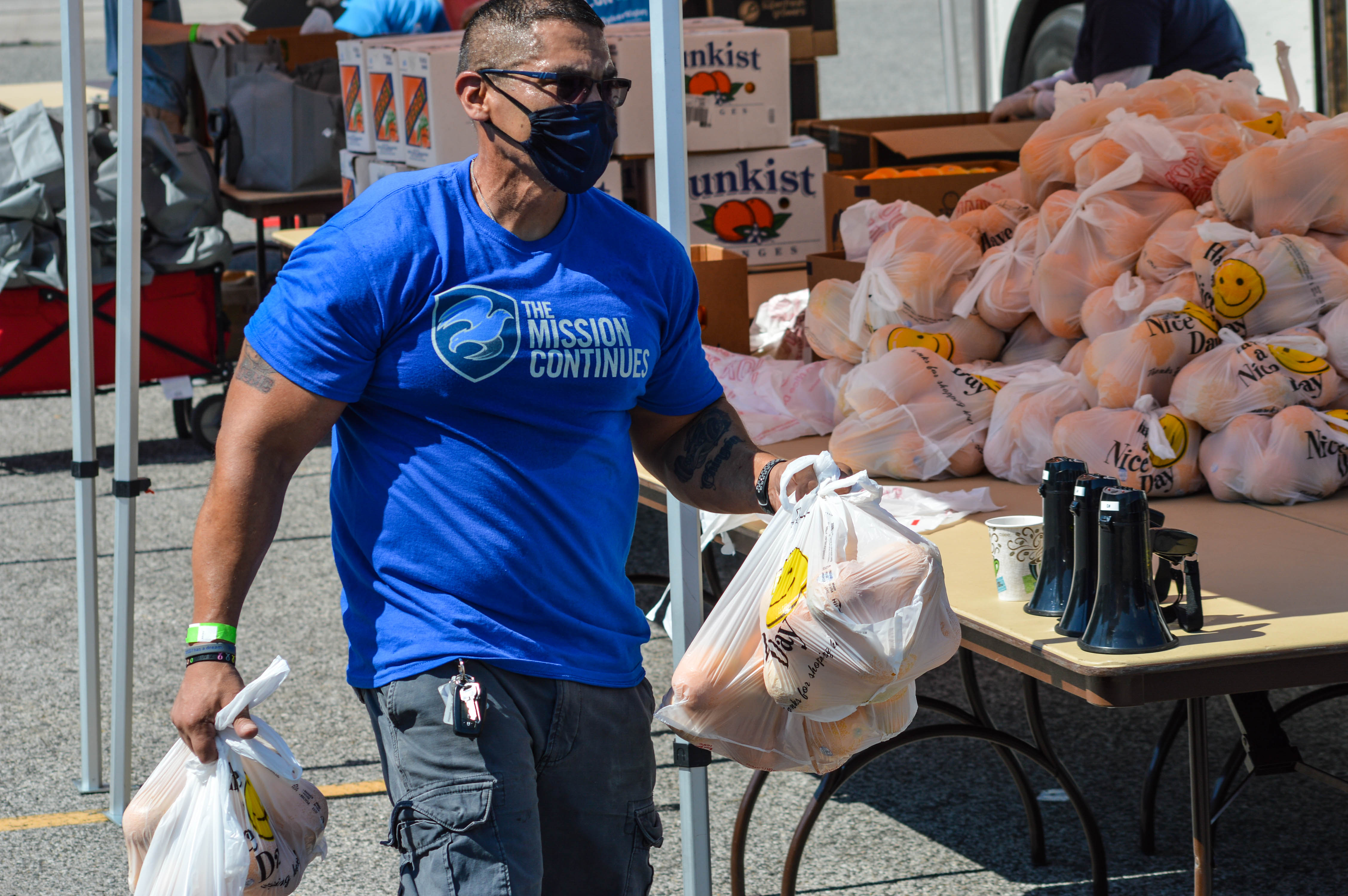 A veteran volunteer with The Mission Continues distributes food in Houston