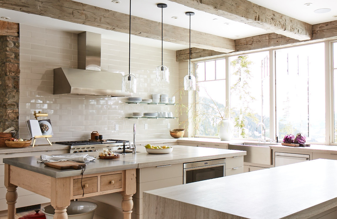 A farmhouse-style antique chopping block is precisely the same height as the island in this light-filled Montana kitchen, designed by WRJ Design with JLF Architects (photo by William Abranowicz).