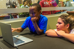 child and woman looking at computer