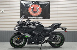 The side image of a pre-owned 2019 Kawasaki Ninja with a Twisted Cycles flag in the background.