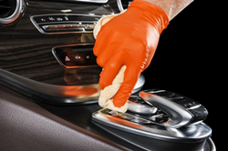 Technician sanitizing console of car