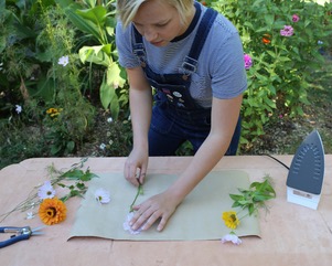 Allison Zeeb, co-owner of NoFarmNeeded, creates a pressed flower design.