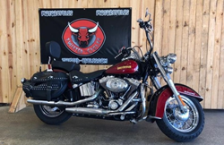 The side view of a red 2010 Harley-Davidson Heritage Softail Classic model, which can be found at Twisted Cycles.