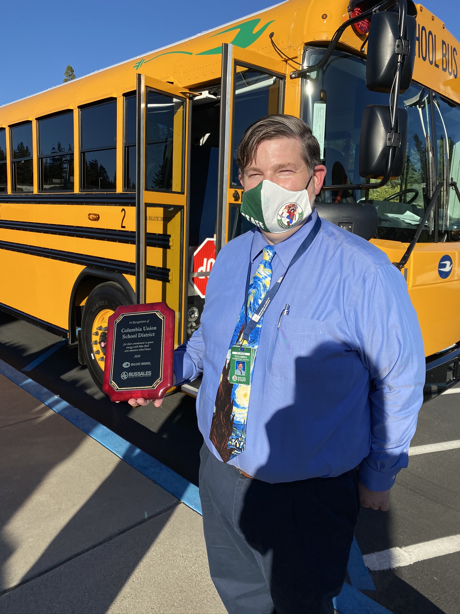 Joe Aldridge, Superintendent at Columbia Union School District accepting recognition plaque from A-Z Bus Sales for their commitment to green energy with Blue Bird zero emission school buses.