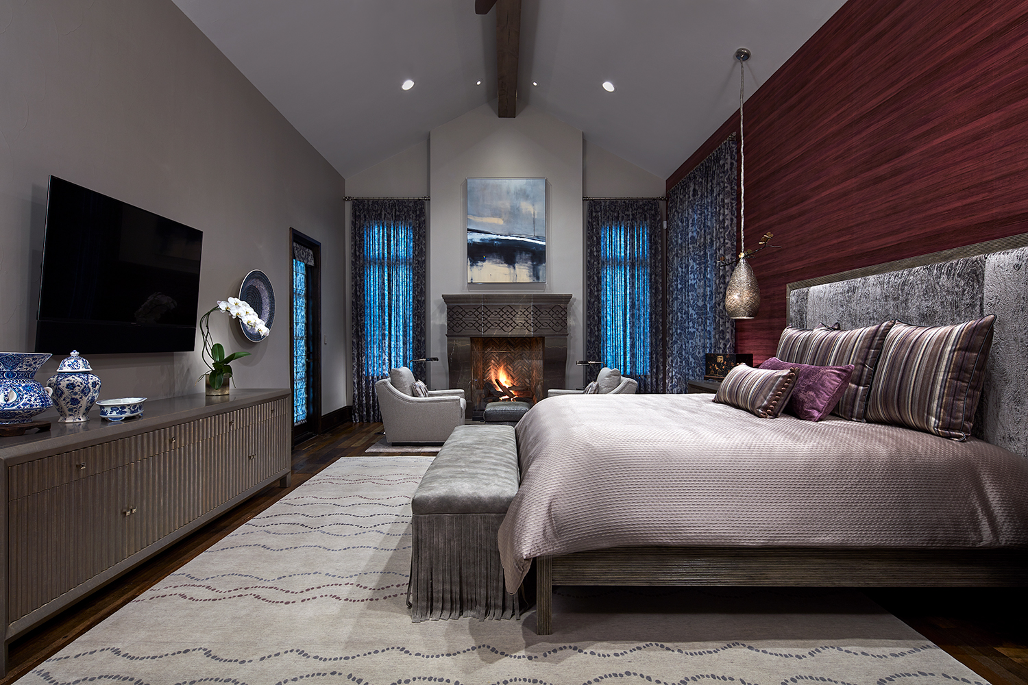 A custom wool rug defines the sleeping area in this master bedroom suite.