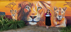 Irma standing in front of a lion mural