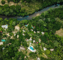 Aerial view looking down at Chaa Creek surrounded by jungle and river