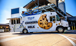 Tiff's Treats' new food truck is parked in front of the entrance to Dell Children's Medical Center, with the phrase "We go together like cookies and milk" across the side of the truck.