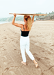 Yoga Practitioner carries the Root Board on the beach