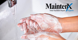A pair of washing hands are covered in soap bubbles, ready to be put under a running faucet in a white sink basin.