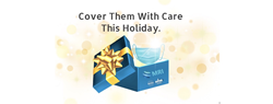 A graphic of a bright blue gift box with an open lid adorned with a shiny gold bow and a sparkling baby blue disposable face mask popping out with the words “Cover Them With Care This Holiday” above the image.