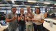 Image shows four people from the Multitudes team who are smiling and holding cupcakes.