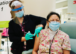 nurse gives female employee vaccine