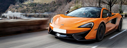 2020 McLaren 570S Coupe orange exterior front fascia driving on bridge