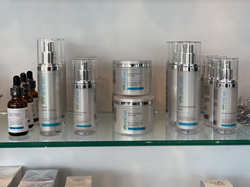 aNū MD products lined up on a glass shelf.