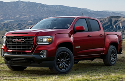 2021 GMC Canyon parked in a field with mountains in the background