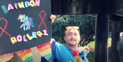 A man holding a sign that says Rainbow Rollers