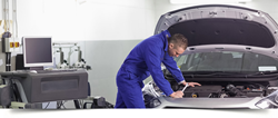 Mechanic looking under the hood of a car