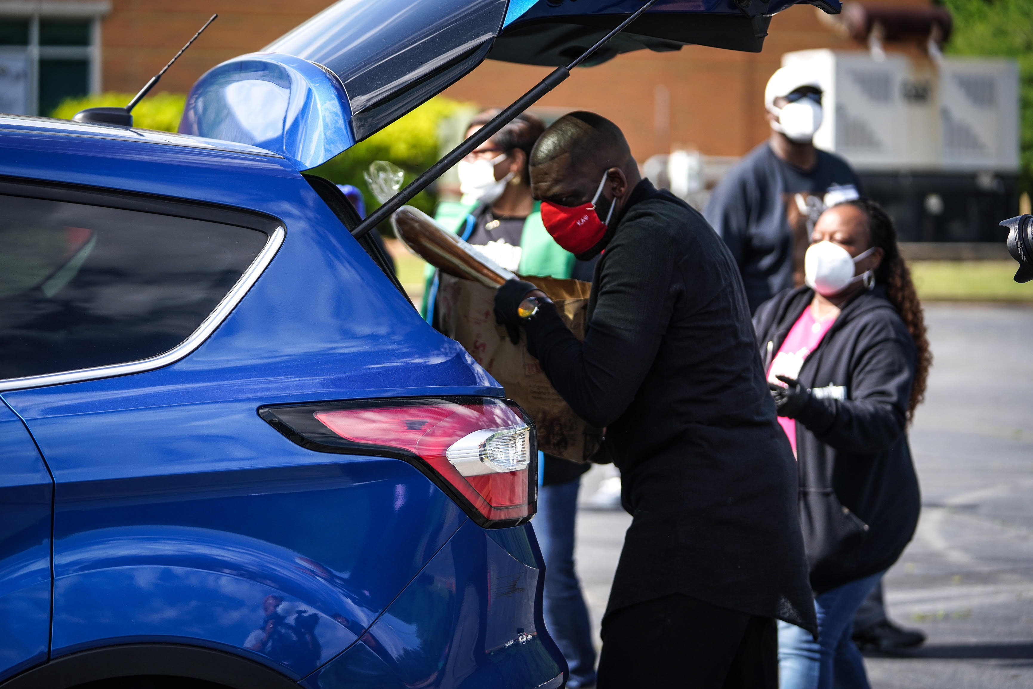 New Birth Missionary Baptist Church Senior Pastor Dr. Jamal Harrison Bryant places a pre-packaged box of food in the truck of a local family as part of The King's Table outreach ministry.