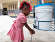 Young girl washes her hands at a Qatar Haiti Fund-sponsored handwashing station at her school in southern Haiti. Photo copyright: Hope for Haiti.